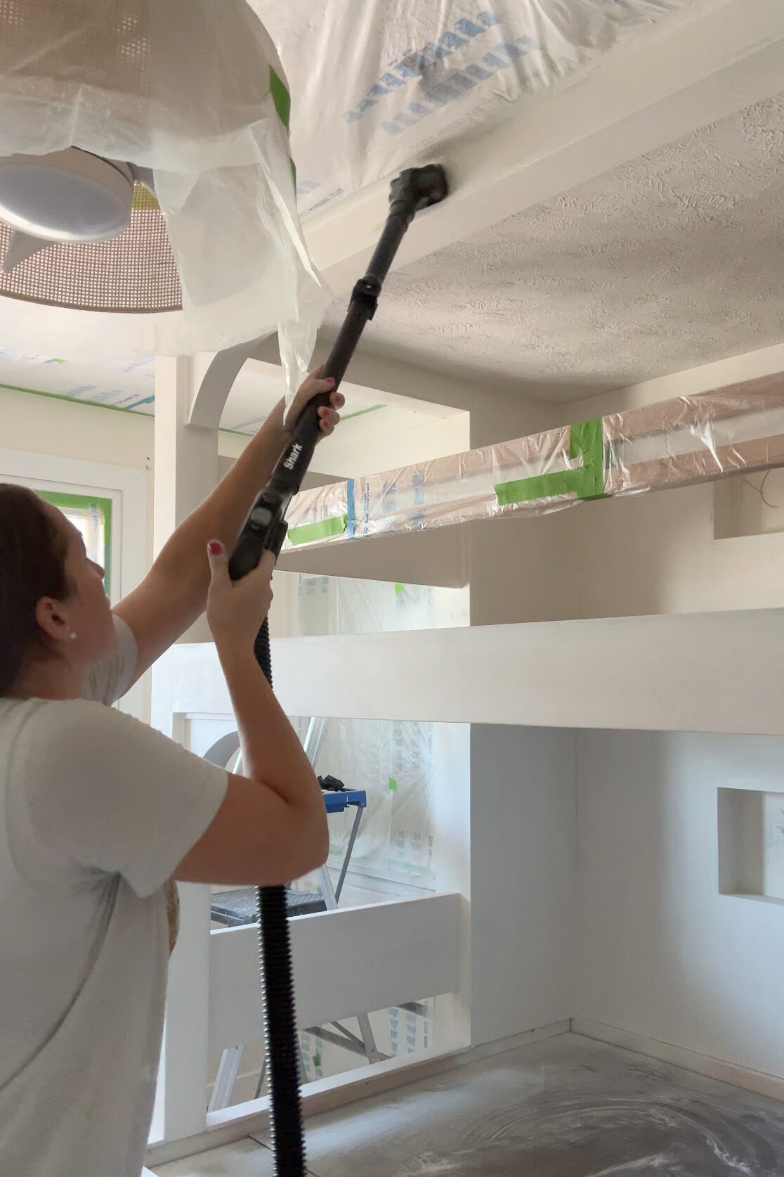 Vacuuming after sanding on a DIY bunk bed.